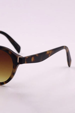 Tortoiseshell round frame sunglasses with gradient lenses and gold accent detail.