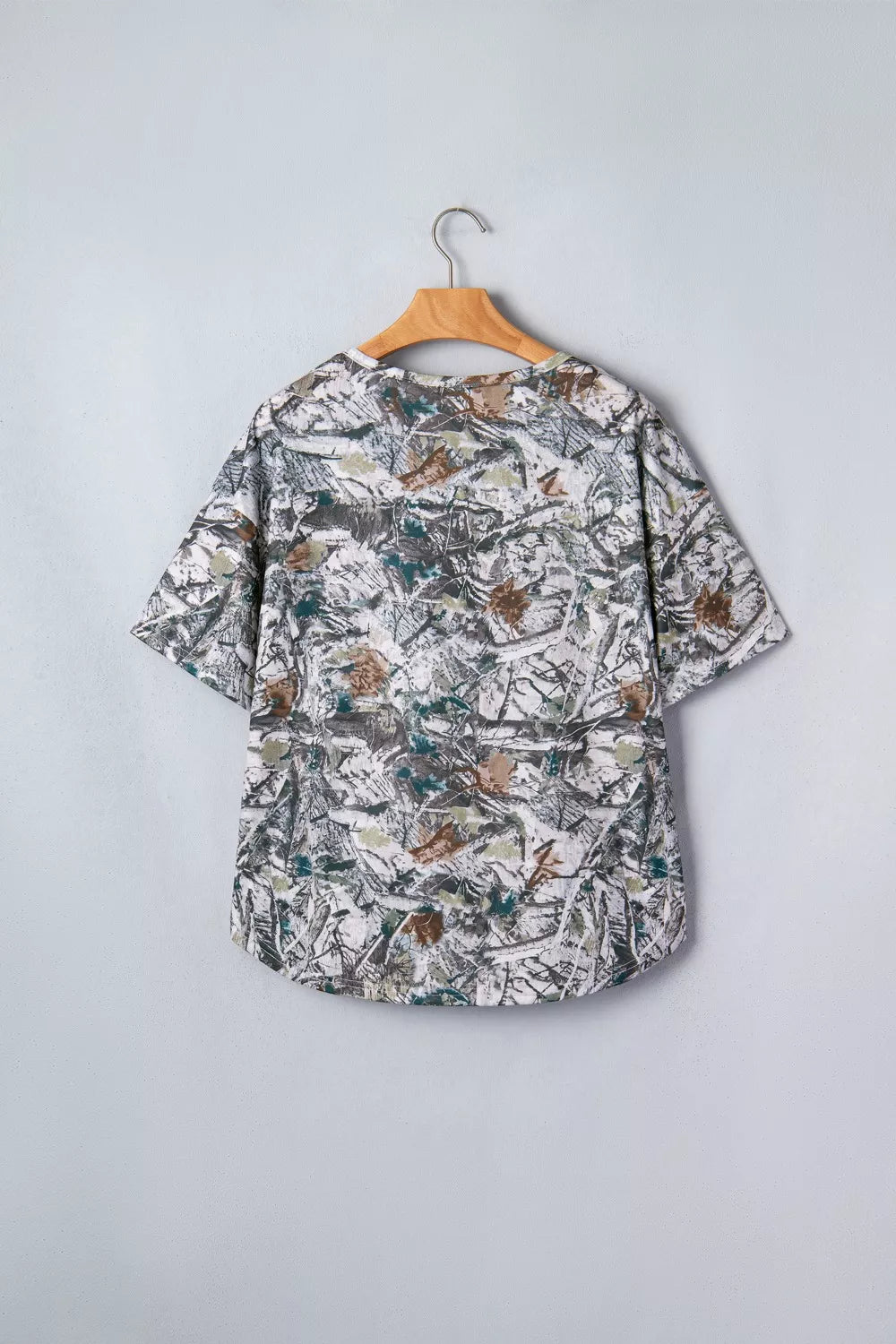 Earthy camouflage print henley t-shirt with short sleeves and a buttoned neckline.