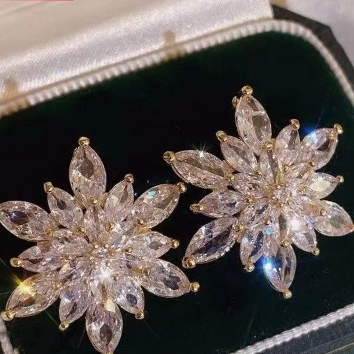 Elegant gold-plated snowflake stud earrings with clear crystal accents.