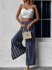 Dark blue palazzo trousers with vertical white stripes and a slit leg.