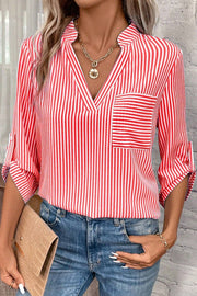 Red and white vertical stripe V-neck blouse with a chest pocket and roll-tab sleeves.