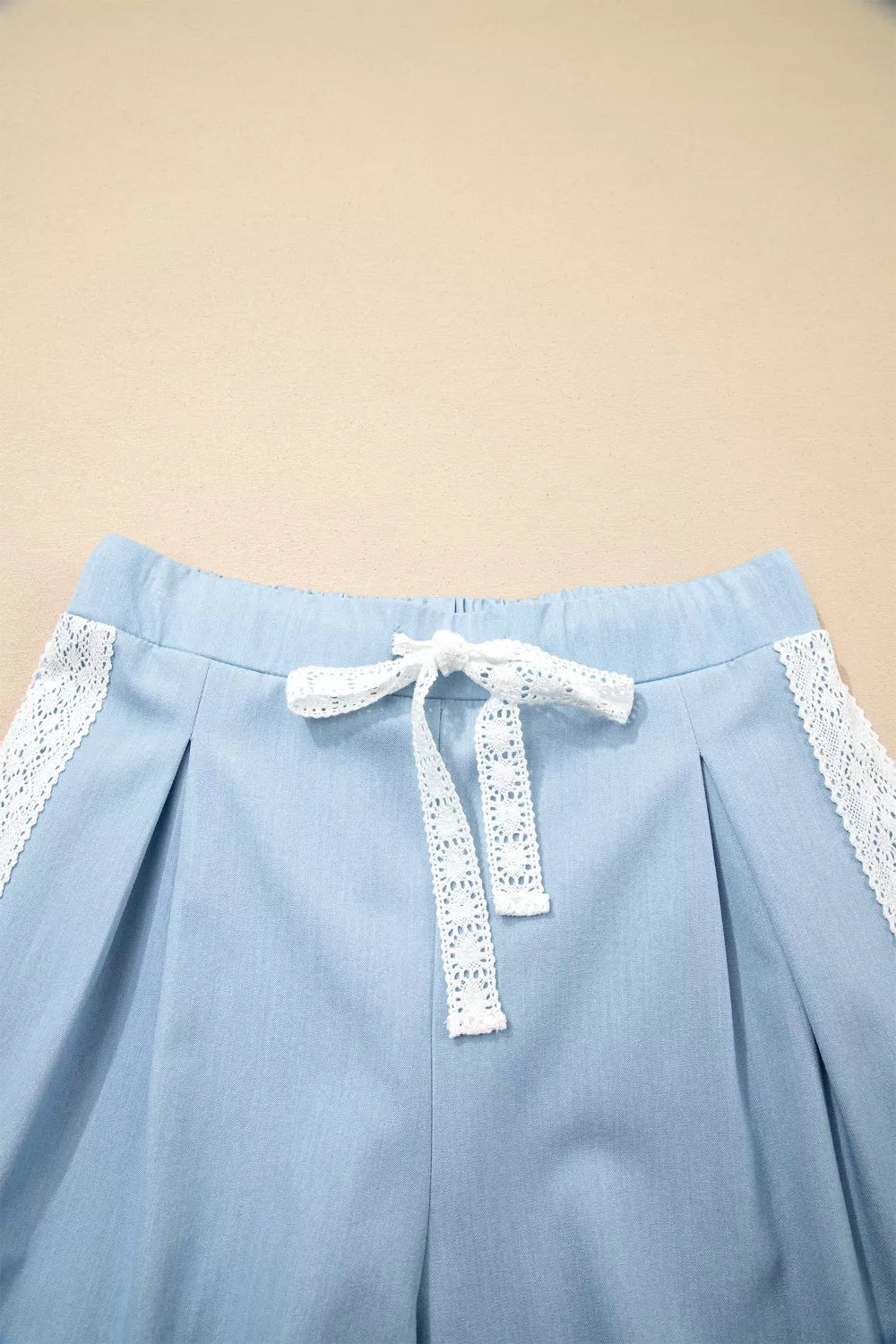 Light blue maternity pants with lace trim and drawstring detail.