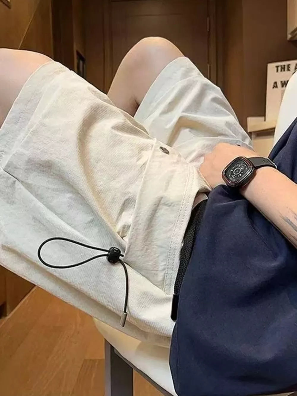 Beige lightweight cargo shorts with drawstring waist and side pocket detail.