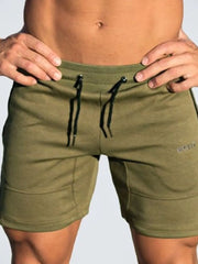 Moss green training shorts with drawstring and subtle logo detail.