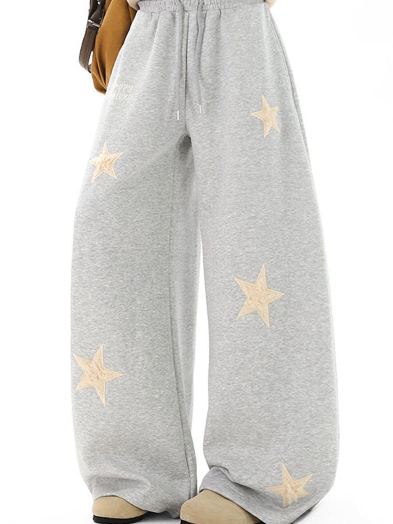 Gray wide leg sweatpants with drawstring and embroidered star appliques.