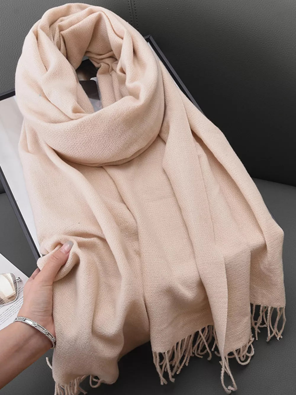 Elegant fringe scarf in light beige with soft texture and fringed edges.