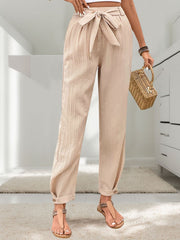 Tan textured linen paperbag trousers with tie waist and cuffed ankles.