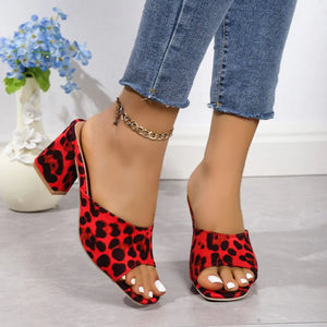 Leopard print block heel mules in deep red with open toe and chunky heel.