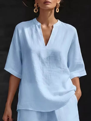 Light blue notched V-neck two-piece set with pockets, casual short sleeve top and shorts.