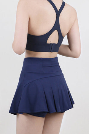 Dark blue active skort with flared pleated skirt and built-in shorts.