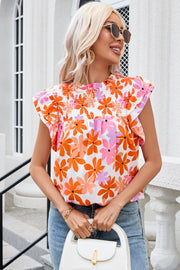 Multicolor floral smocked bodice blouse with flutter sleeves and a round neckline.