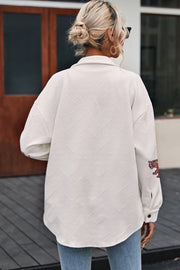 White quilted overshirt with geometric pattern and embroidered tiger detail on sleeve.