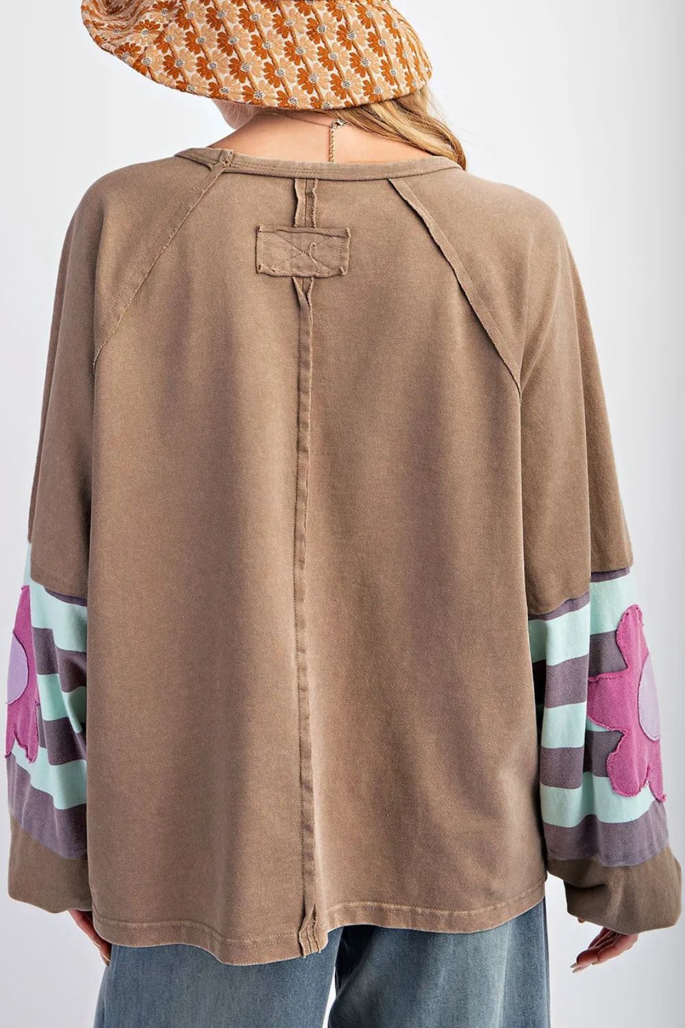 Camel raglan sleeve top with floral appliqué and striped sleeves.