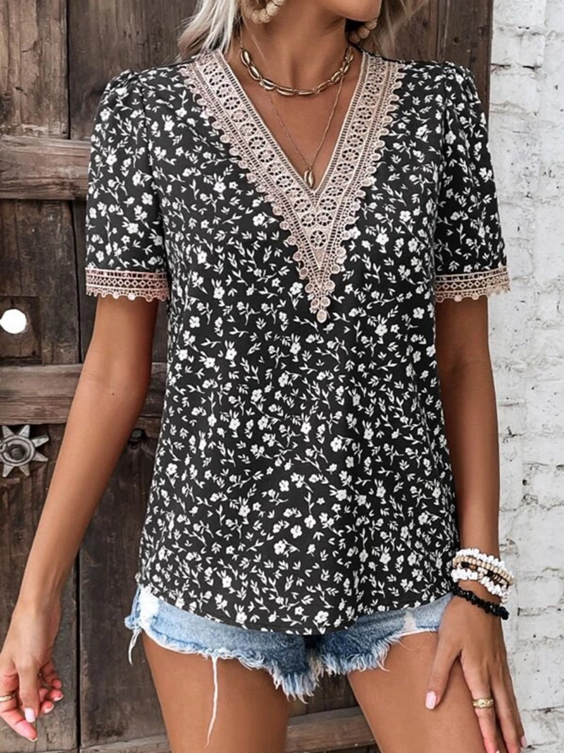 Black floral V-neck blouse with lace trim and short sleeves