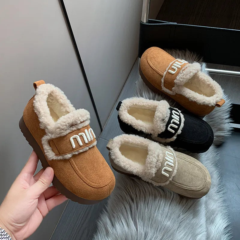 Logo strap shearling loafers in caramel, black, and beige with plush lining.