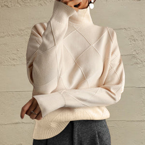 Ivory turtleneck pullover with diamond knit texture and ribbed cuffs and hem.