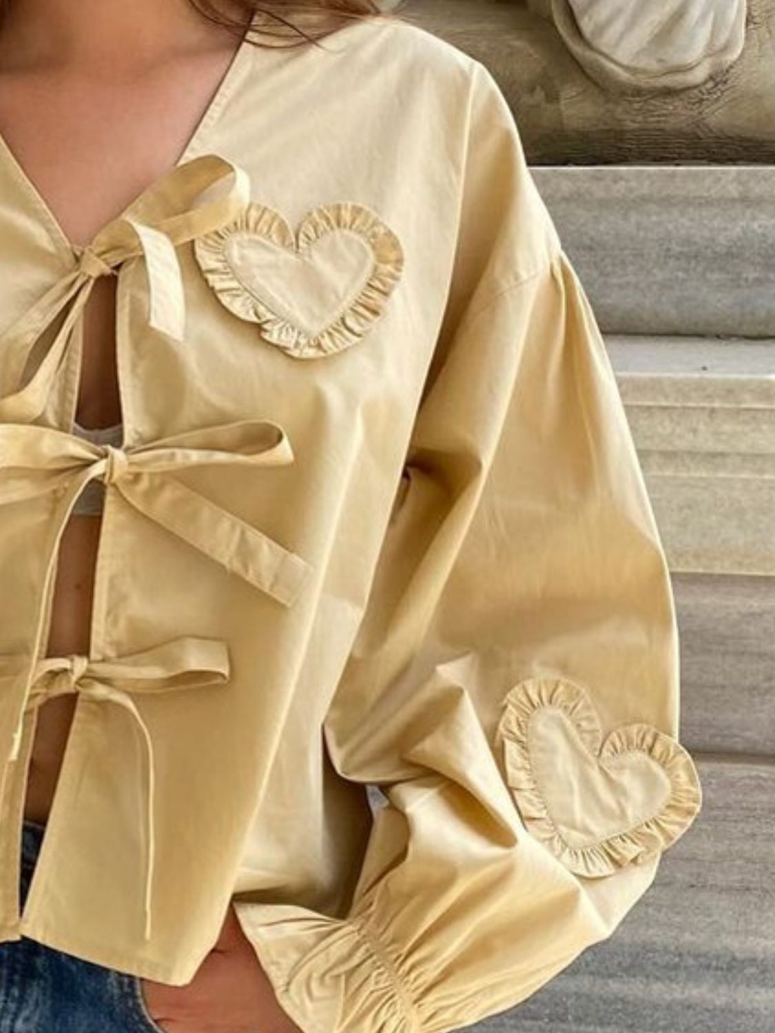 Pastel yellow blouse with heart appliqués and tie closures.