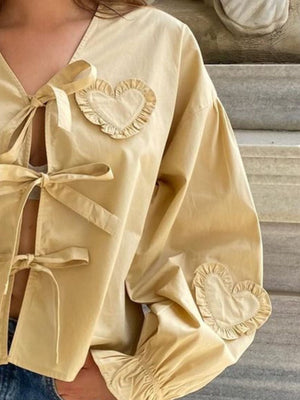 Pastel yellow blouse with heart appliqués and tie closures.