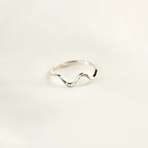 Silver serpentine diamond contour ring with a wavy band.