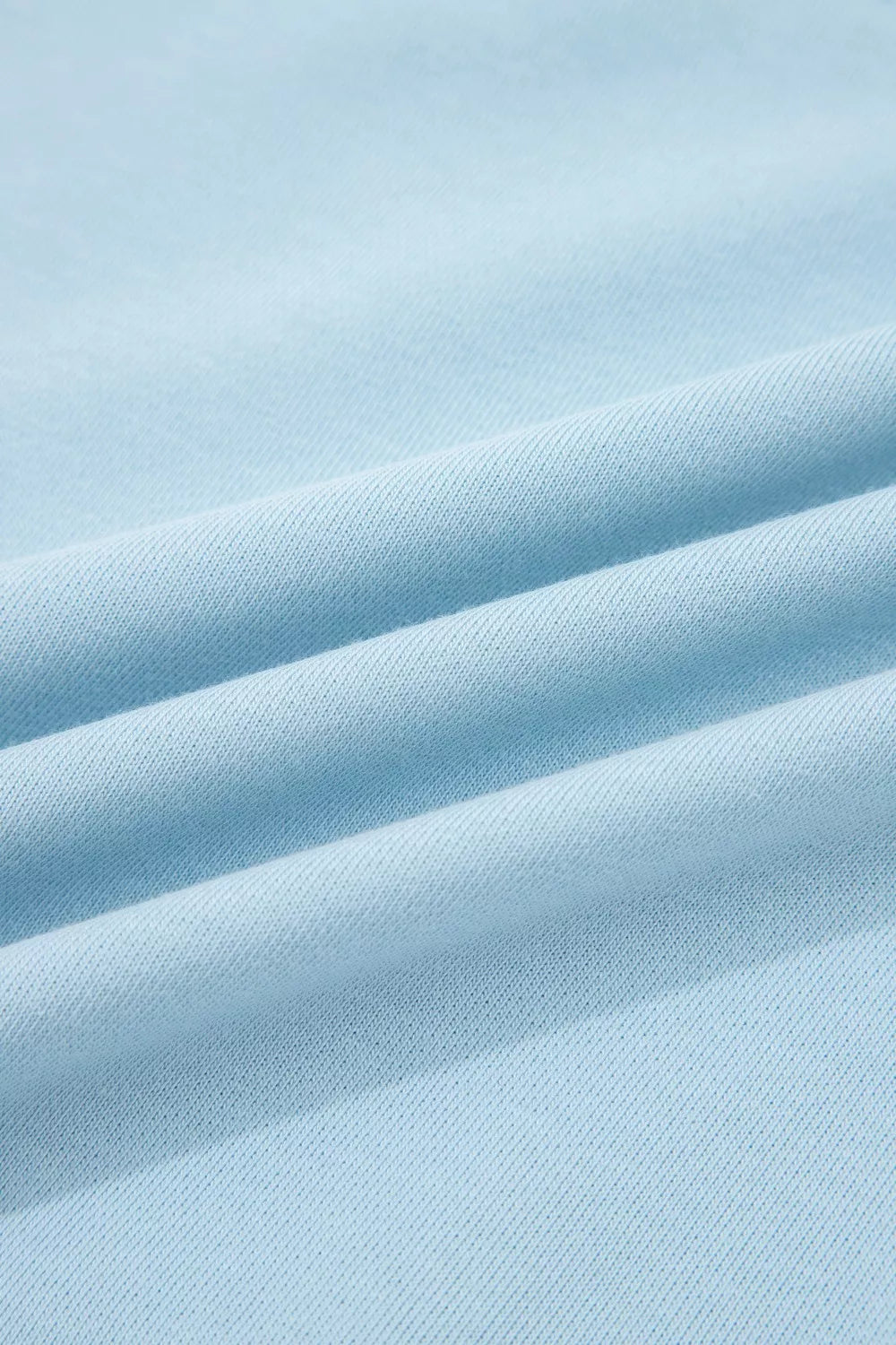 Light blue cotton bikini fabric with textured weave and soft folds.