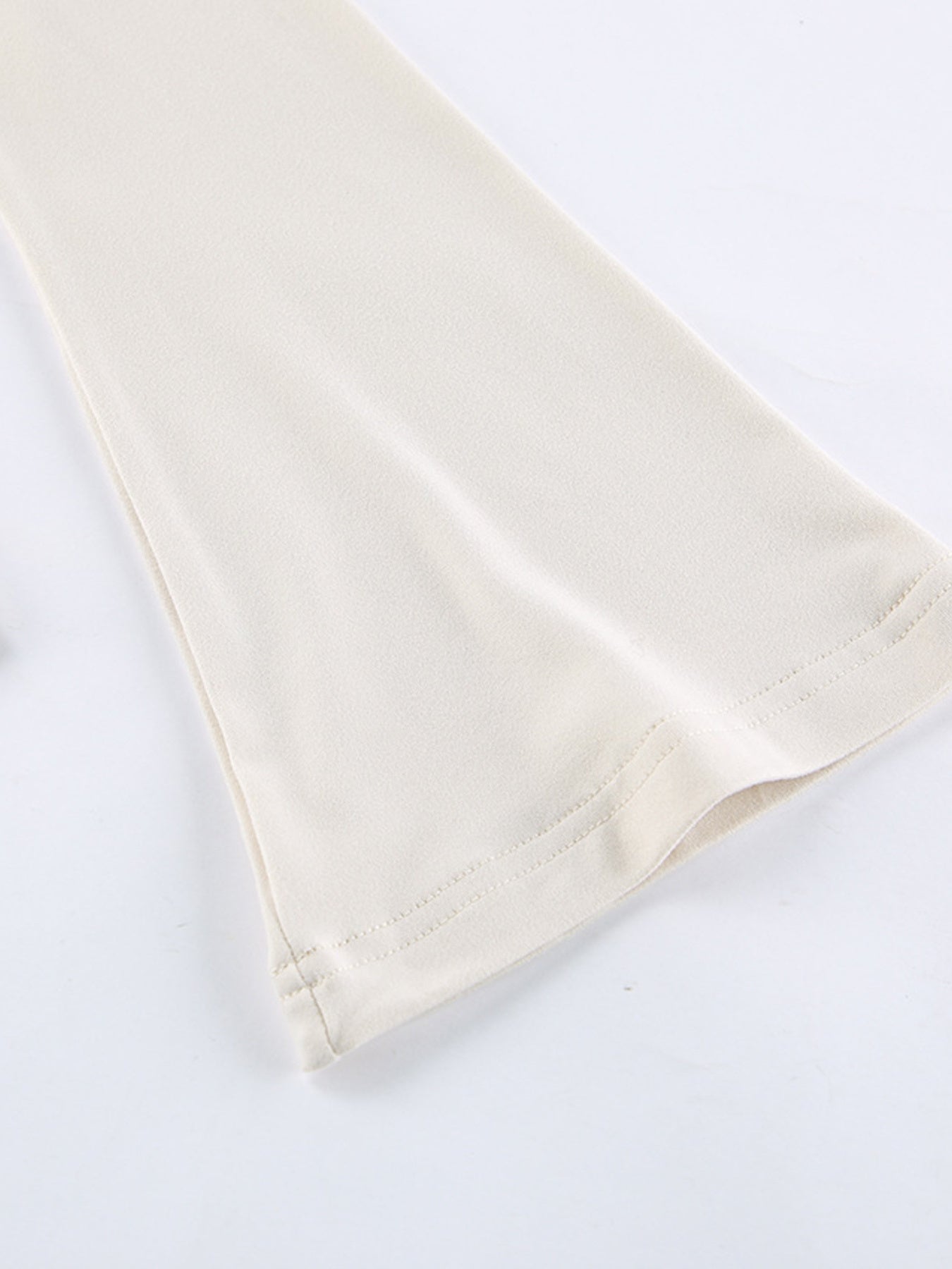 Beige long-sleeve shirt with knot front and cutout detail.