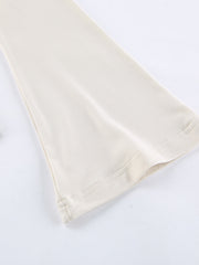 Beige long-sleeve shirt with knot front and cutout detail.