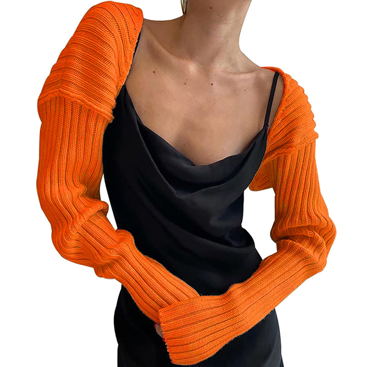 Orange ribbed knit shrug with extended sleeves styled over a black slip dress.