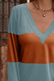 Colorblock V-neck sweater with long sleeves in blue and rust orange.