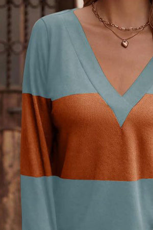 Colorblock V-neck sweater with long sleeves in blue and rust orange.