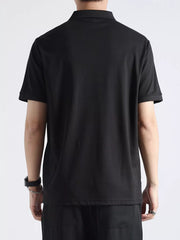 Black textured casual polo shirt with button accents, short sleeves, and a classic collar.