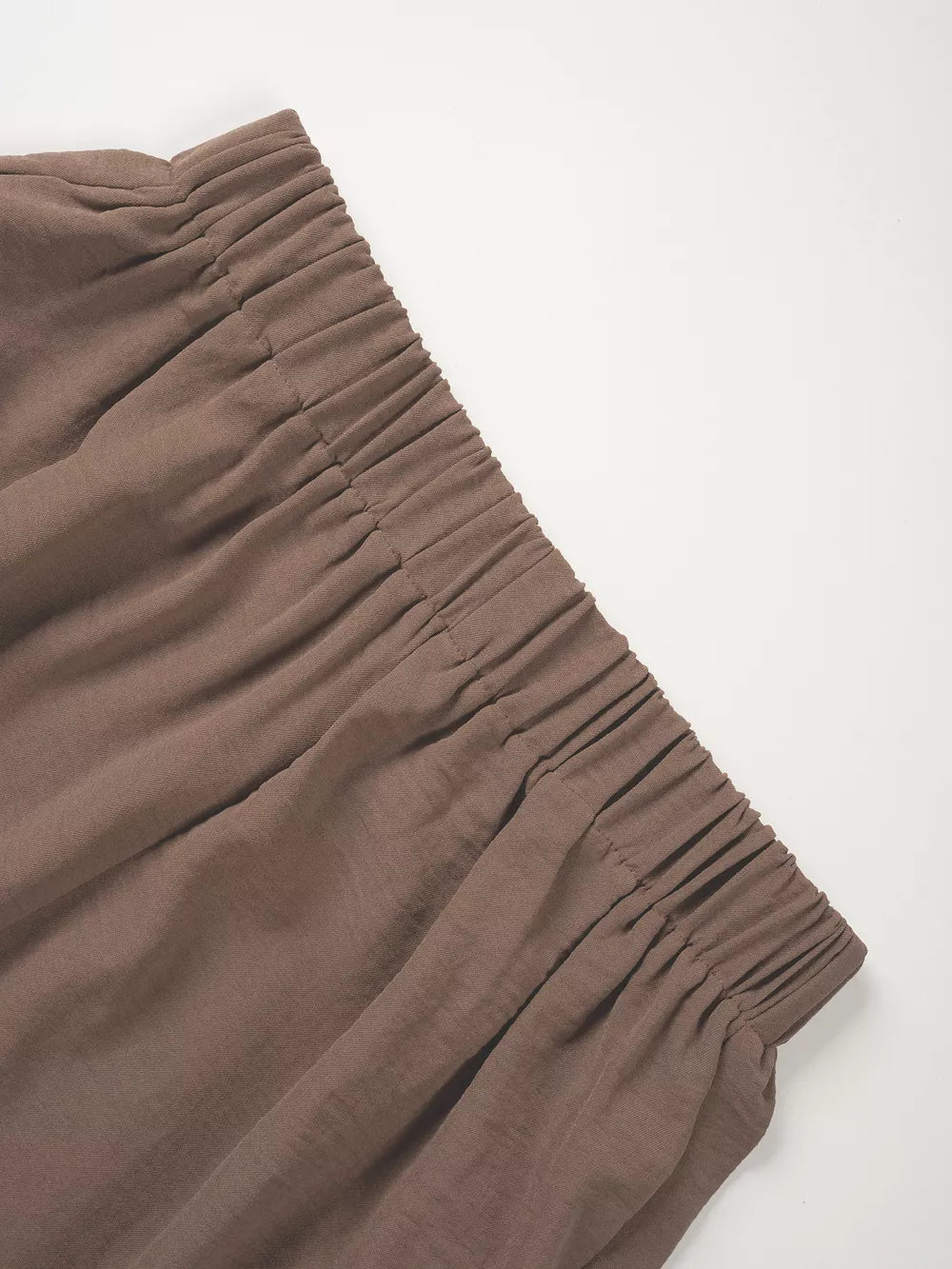 Taupe cropped vest and wide-leg pants ensemble detail showing elastic waistband and textured fabric.