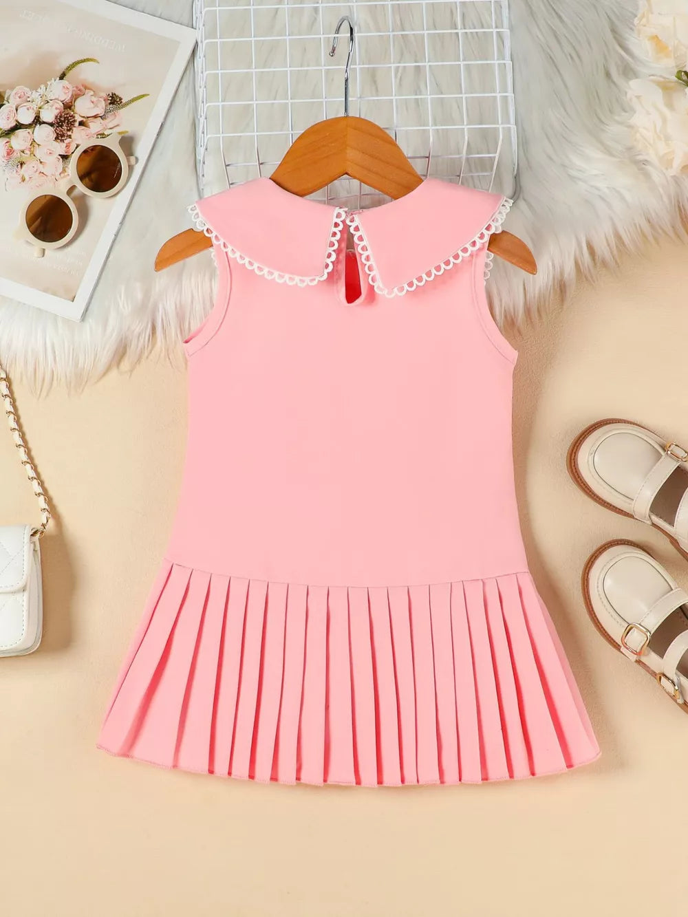 Pink toddler dress with lace collar and pleated skirt