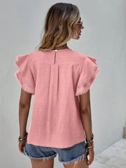 Dusty pink blouse with ruffle sleeves and pom-pom trim, featuring a keyhole back detail.