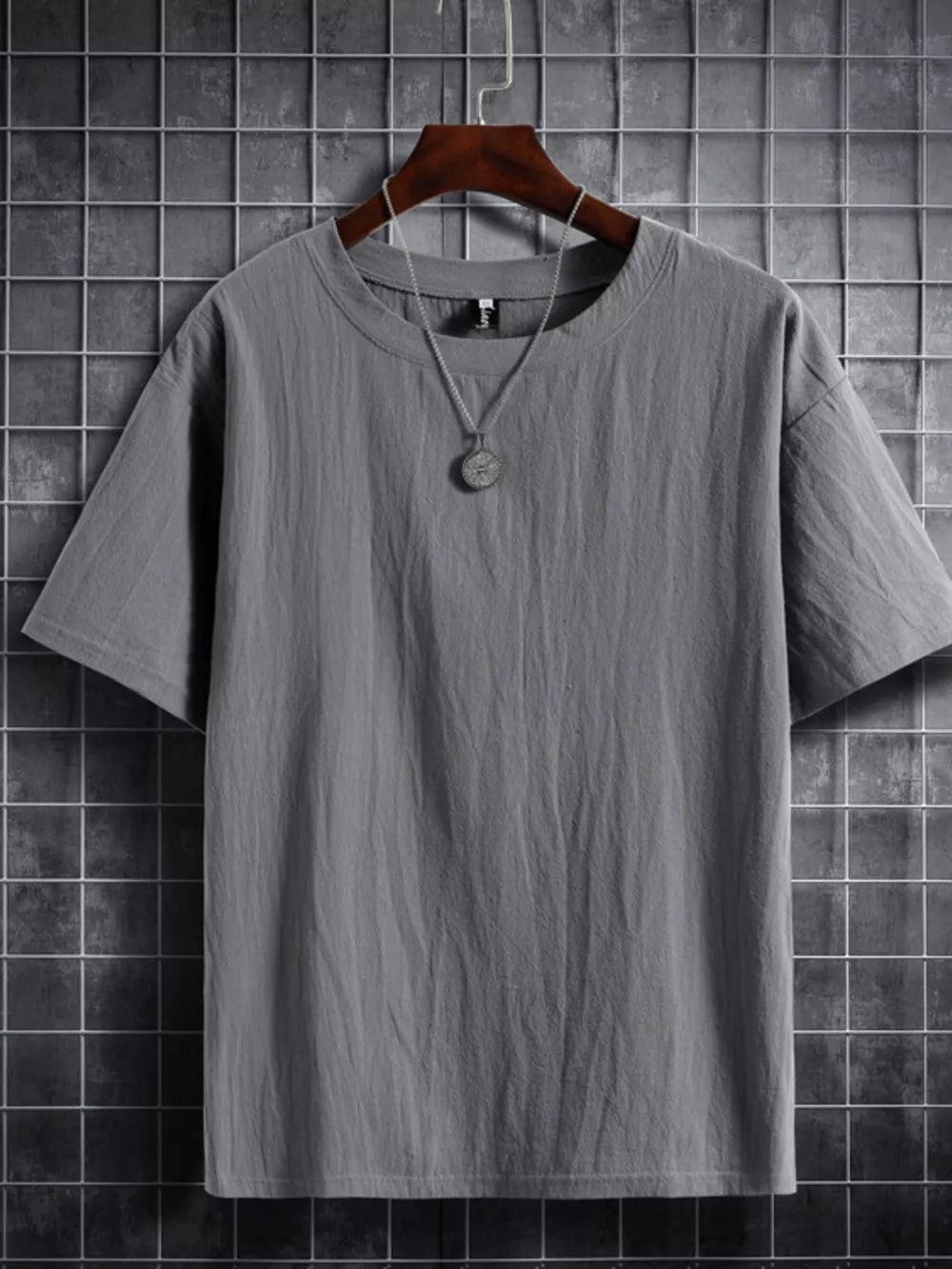 Grey cotton crew neck t-shirt with textured fabric and short sleeves.