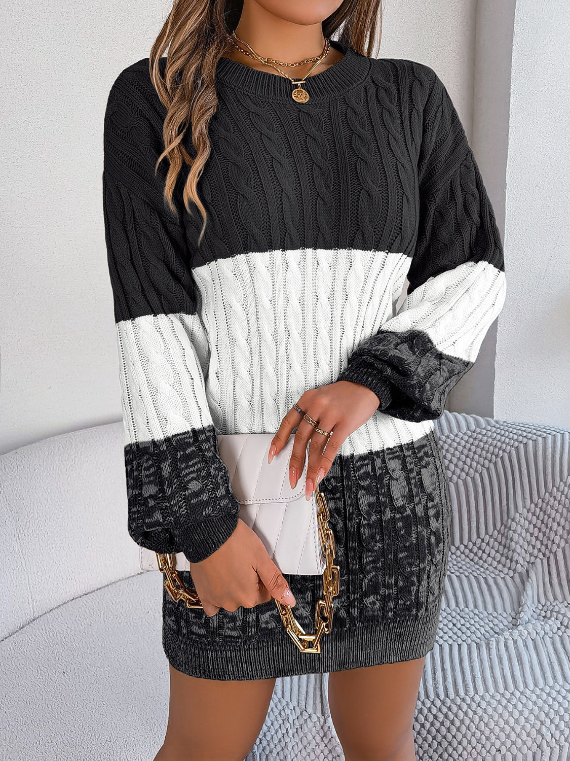 Colorblock cable knit mini dress in black and white acrylic with crew neck and long sleeves.