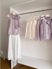 Sleeveless purple shirt with a large bow detail on the neckline.