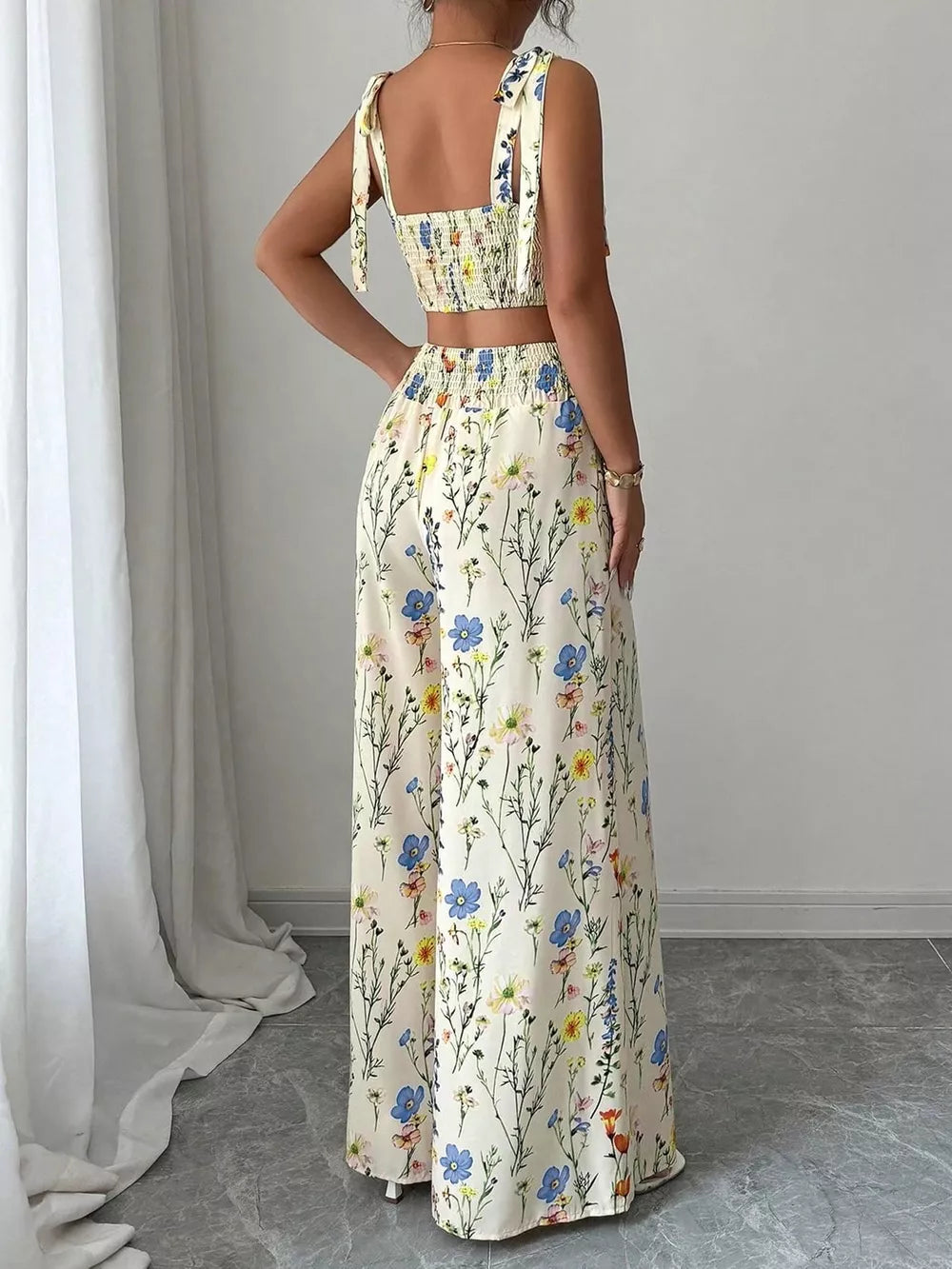 Floral print crop top and wide-leg pants set with adjustable tie straps.