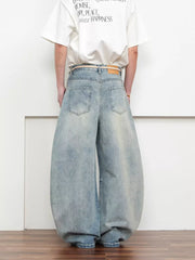 Belted wide leg jeans in light blue denim with a balloon silhouette.