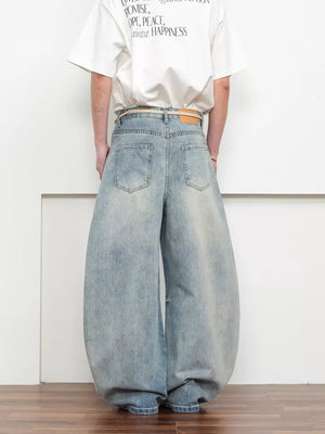 Belted wide leg jeans in light blue denim with a balloon silhouette.