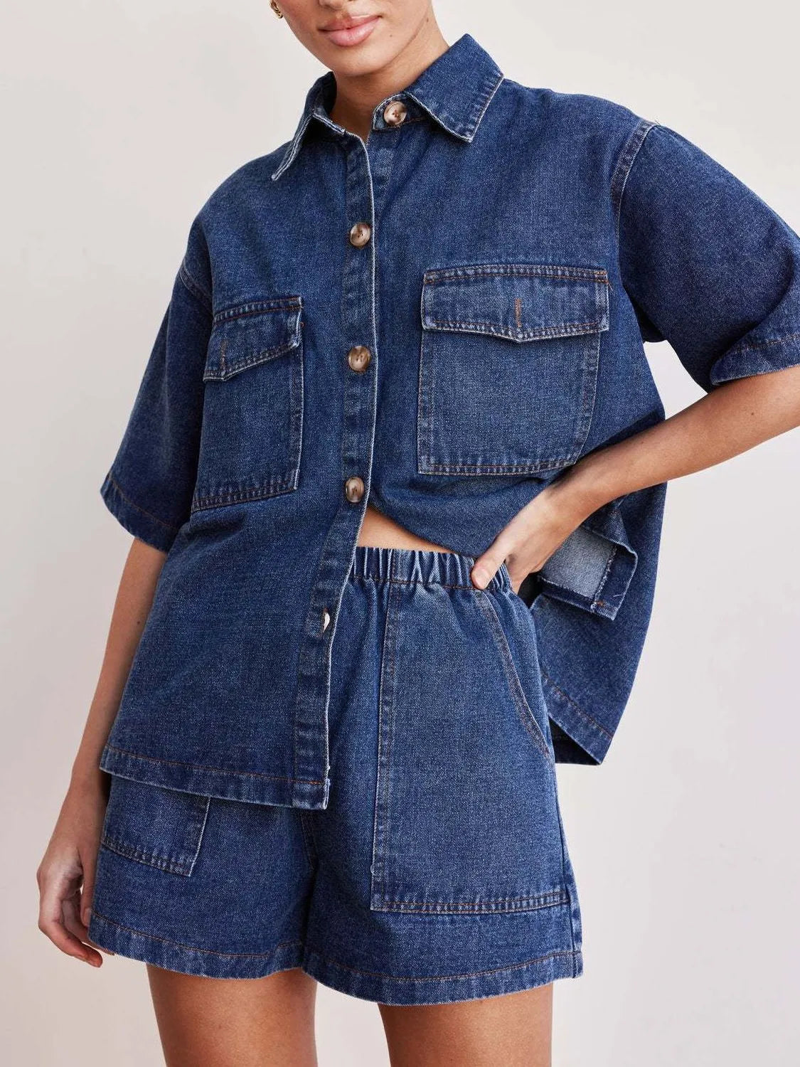 Medium wash denim co-ord set with short sleeve button-up shirt and elastic waist shorts.
