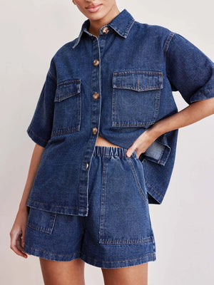 Medium wash denim co-ord set with short sleeve button-up shirt and elastic waist shorts.