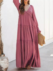Smocked V-neck tiered maxi dress in wine red with long sleeves and a flowing skirt.