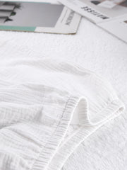 White cotton pajama shorts with textured fabric and elastic waistband