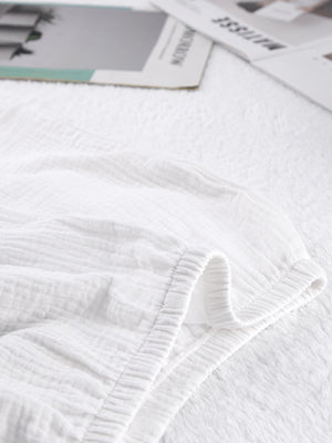 White cotton pajama shorts with textured fabric and elastic waistband