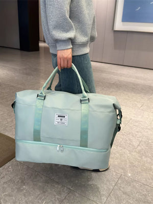 Light green duffel bag with dual handles and a zippered bottom compartment.