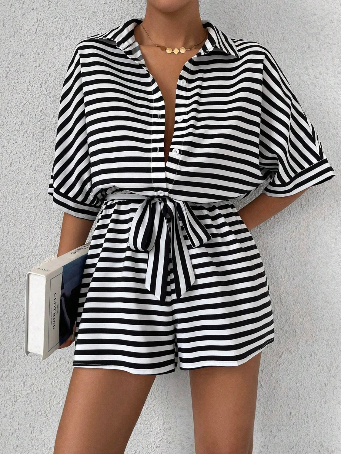 Black and white striped shirt romper with self-tie belt and button front.