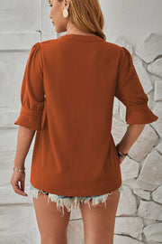 Brown puffed sleeve blouse with flared cuffs and a relaxed fit.