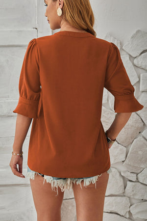 Brown puffed sleeve blouse with flared cuffs and a relaxed fit.