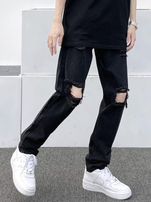 Black distressed slim fit jeans with ripped knees, made of 100% cotton.