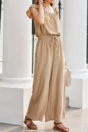 Tan textured ruffle-sleeve drawstring palazzo jumpsuit with wide legs and elastic waist.